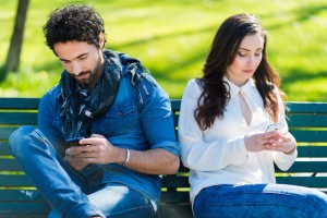Couple not talking to each other typing on mobile phones